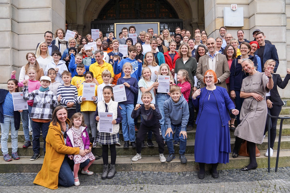 Die Schüler*innen freuen sich mit Oberbürgermeister Belit Onay über ihre Preise