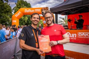 Stefan Sander (rechts), Geschäftsleitung HR ROSSMANN, erhält Wertschätzung für das Engagement aller Mitarbeiterinnen und Mitarbeiter des Unternehmens bei den B2Run-Läufen. 