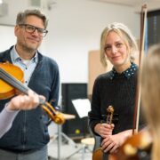 Thomas Weinert, Vonovia Regionalleiter Hannover, besucht Geigenlehrerin Rebecca Czech und ihre Schülerinnen und Schüler beim Geigenunterricht